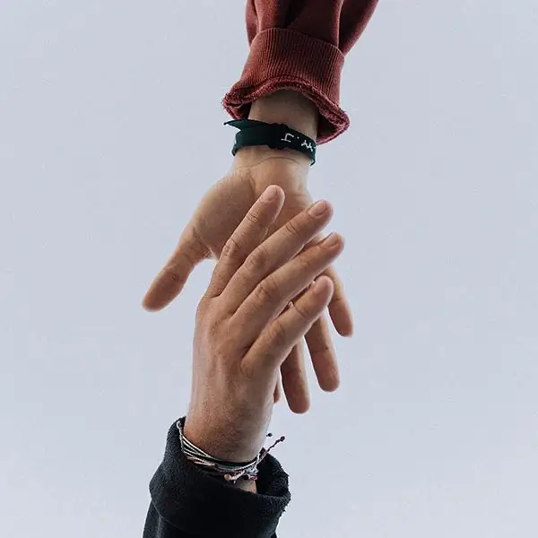 Two hands reaching to grasp each other in symbol of teamwork